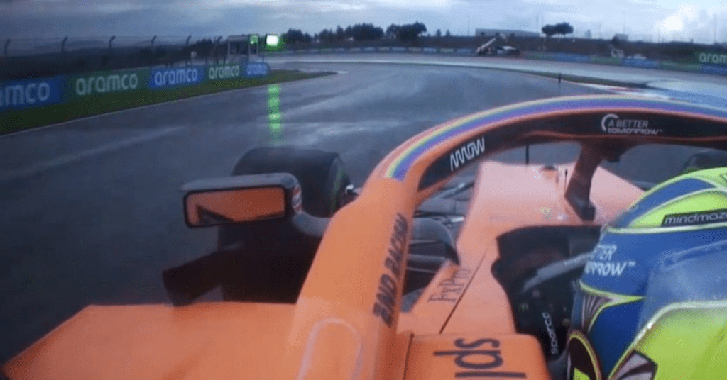 Lando Norris passes the crane on track, with a visible green light on his left. © F1TV